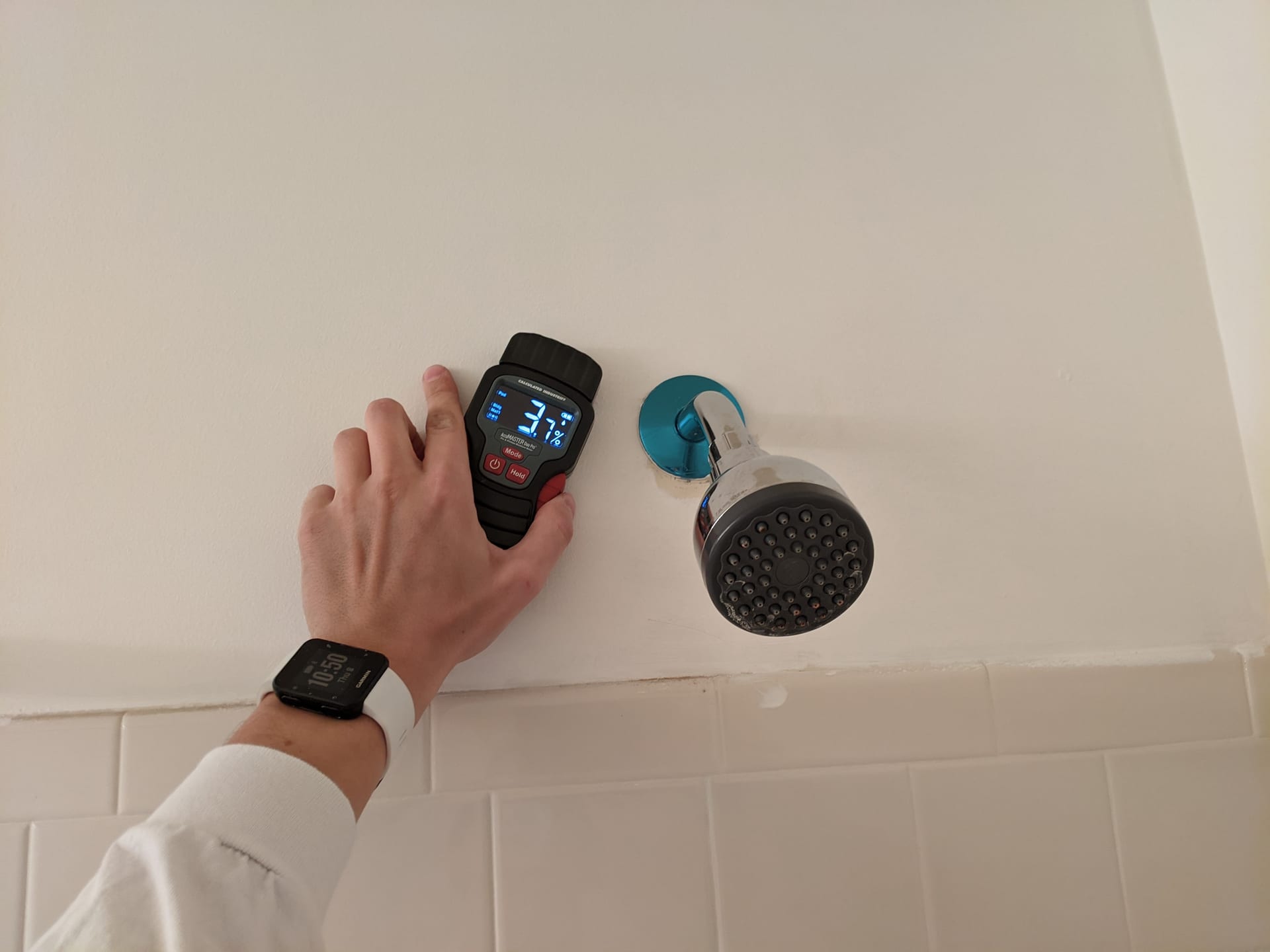 Inspector measuring wall moisture content with high precision meter