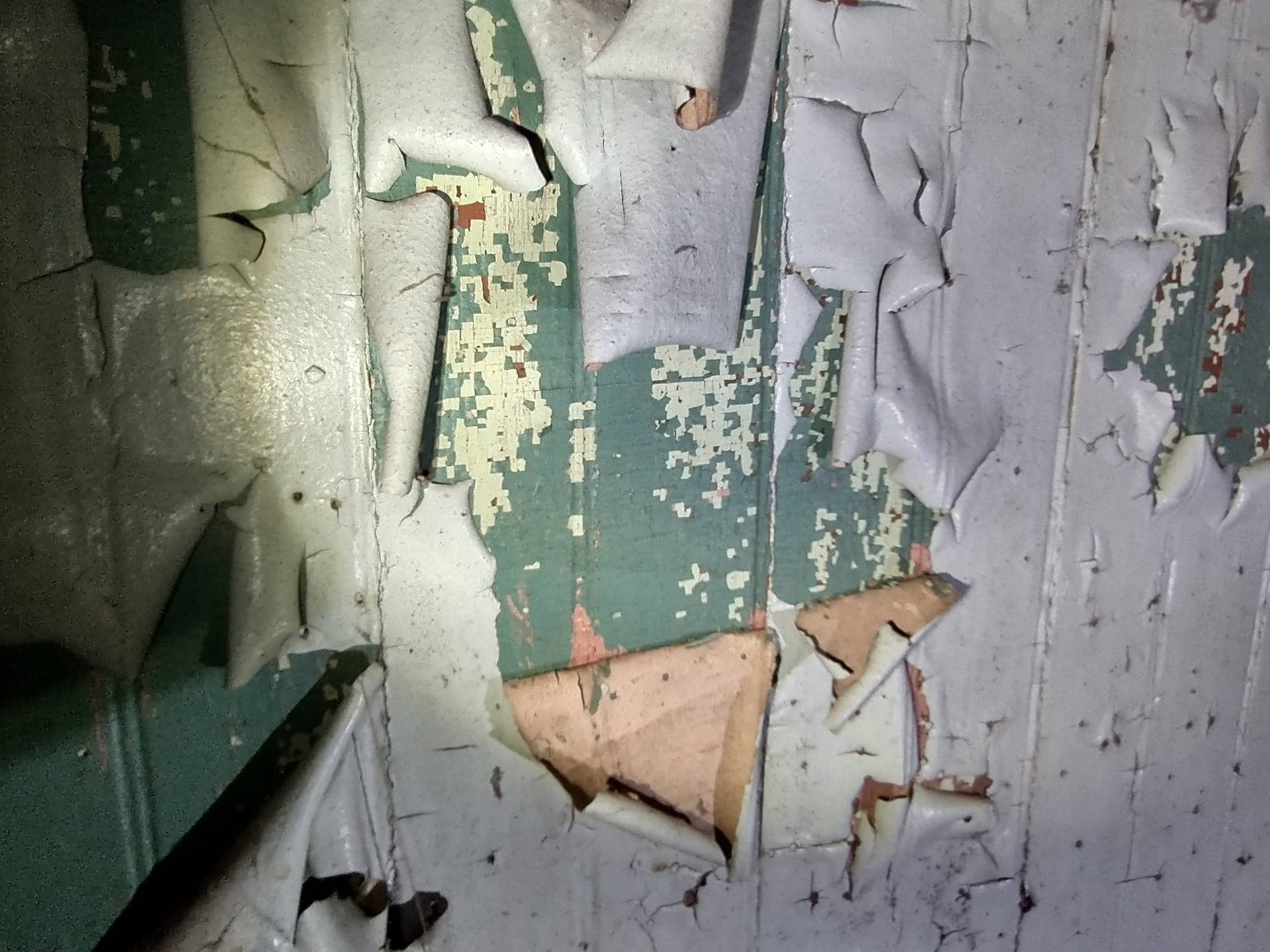 Peeling layers of lead paint on historic interior wall